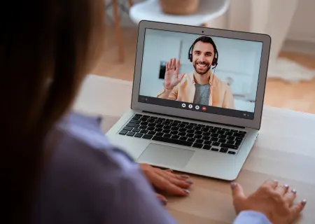 Mulher olhando para homem em videochamada em laptop durante mentoria remota. Ele acena pra ela - Imagem de Freepik